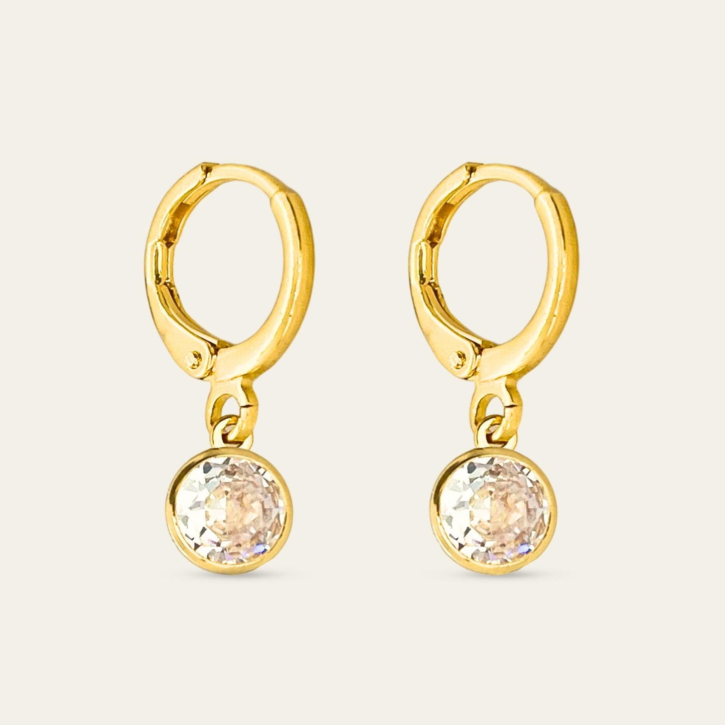 Aros huggies enchapados en oro 18k con punto de luz, sobre fondo blanco - Coca Johnson Joyas - Chile