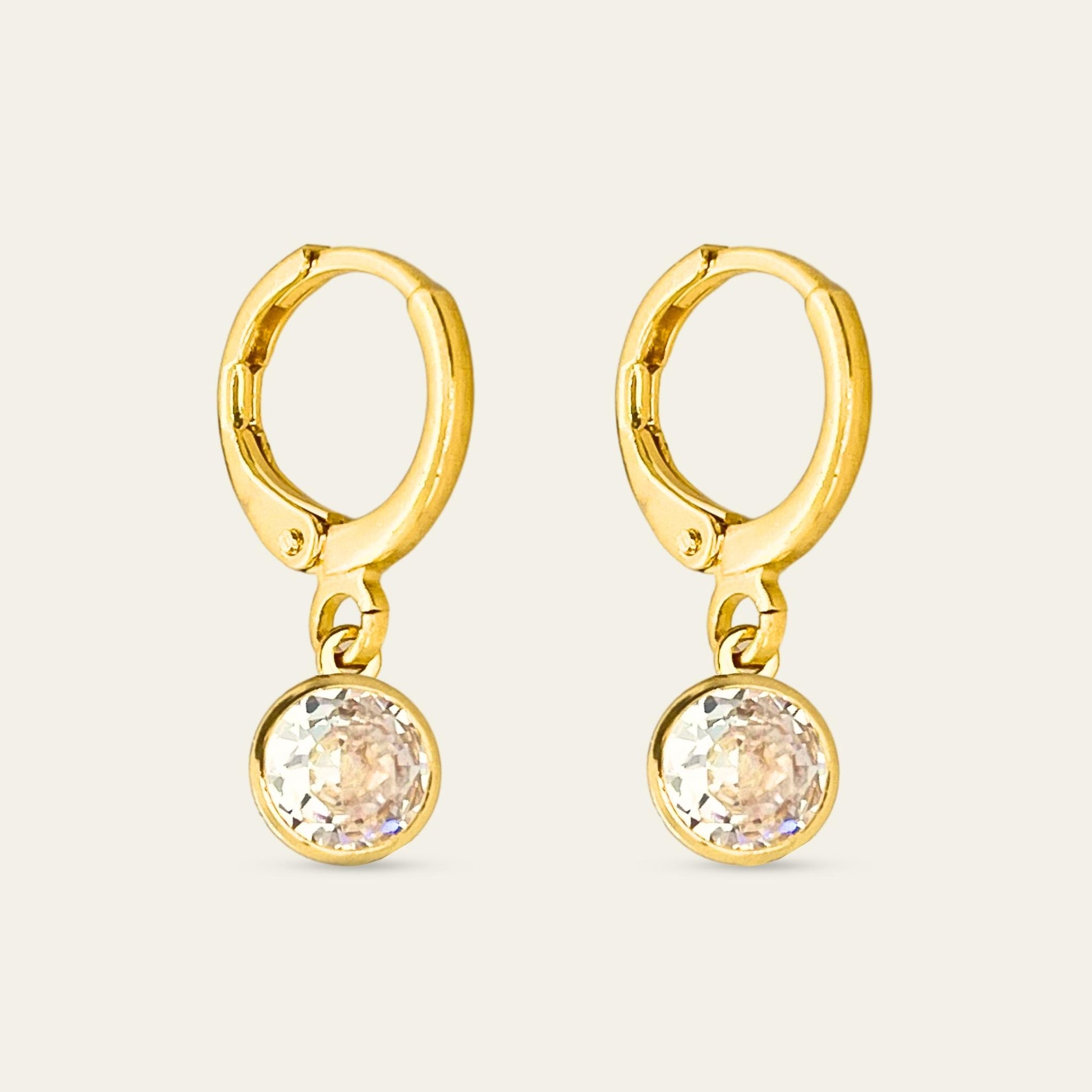 Aros huggies enchapados en oro 18k con punto de luz, sobre fondo blanco - Coca Johnson Joyas - Chile