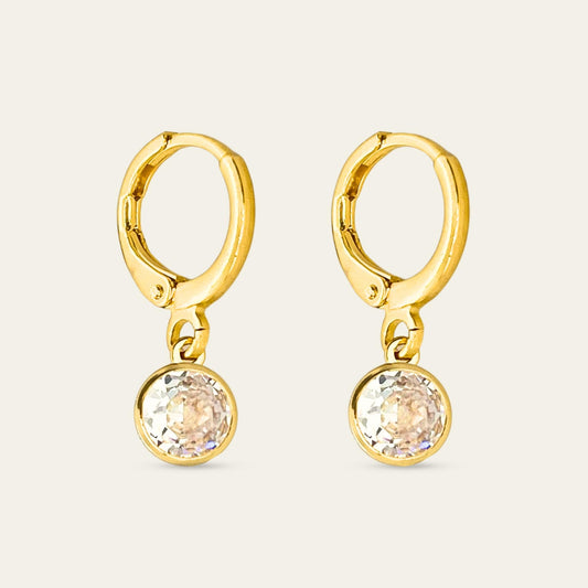 Aros huggies enchapados en oro 18k con punto de luz, sobre fondo blanco - Coca Johnson Joyas - Chile
