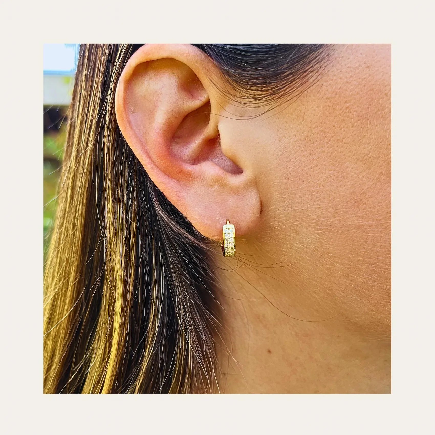 Aros tipo huggies con circones enchapados en oro de 18 kt, usado solo en la oreja de una mujer - Coca Johnson Joyas - Chile