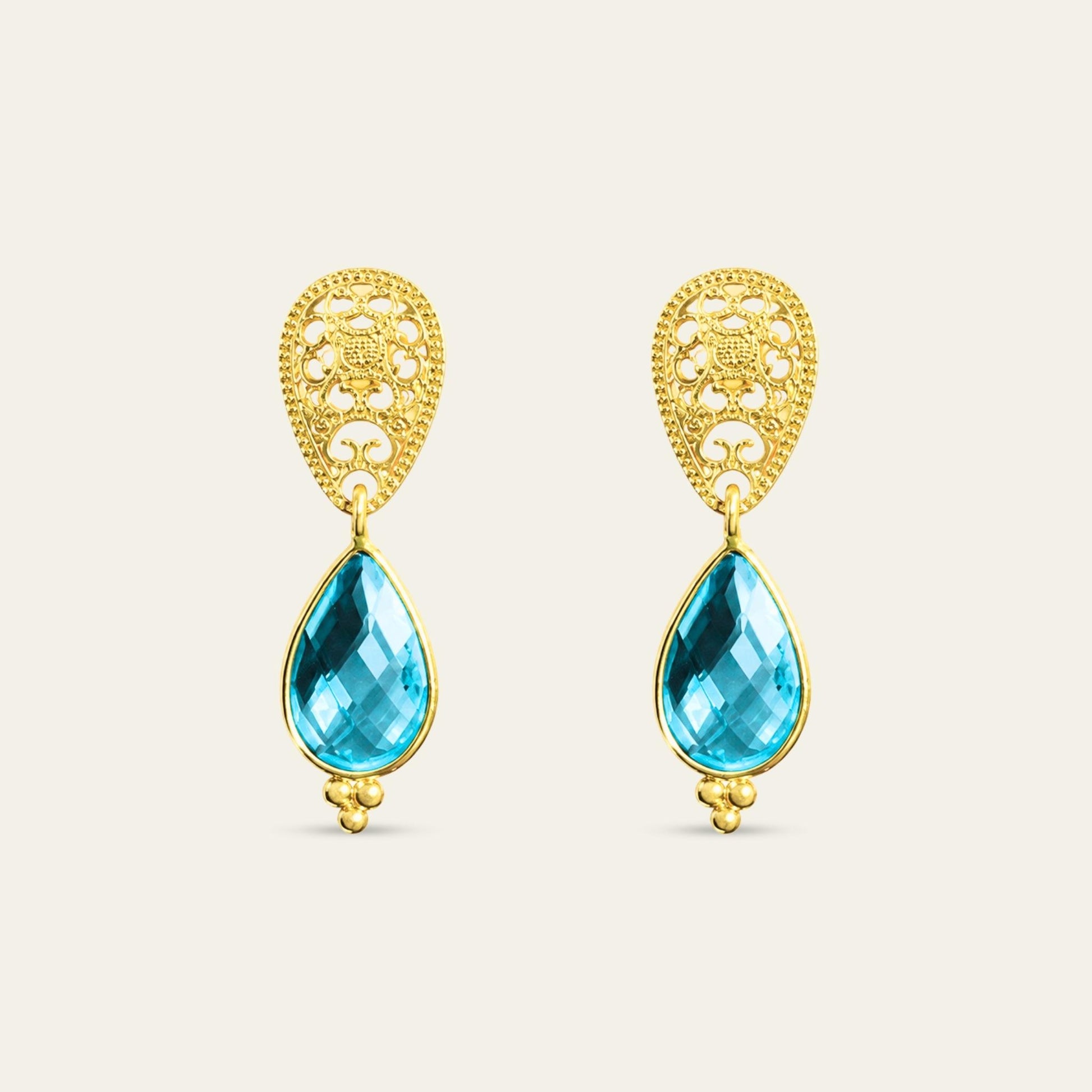 Aros con gota R color topacio azul suizo y base calada enchapados oro 18k. sobre fondo blanco - Coca Johnson Joyas - Chile