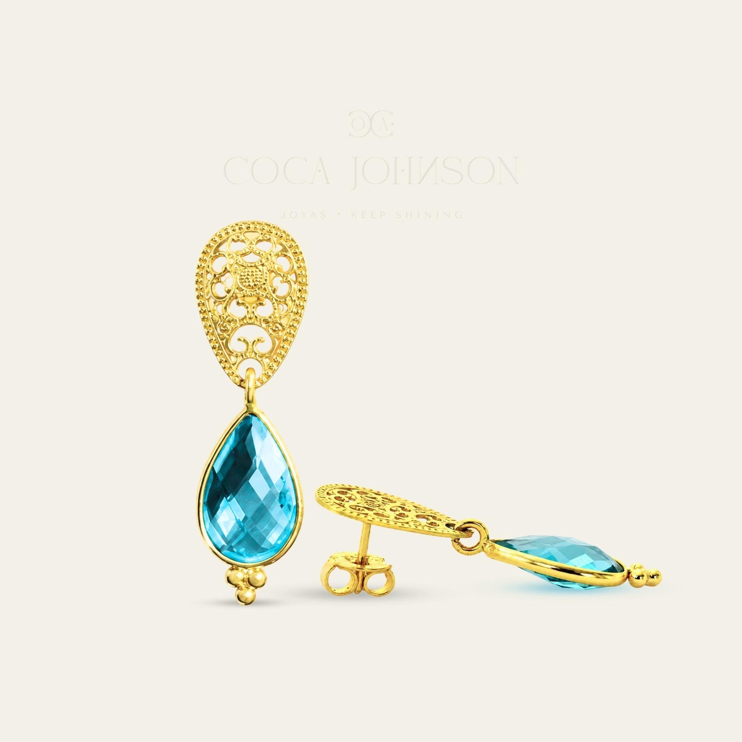 Aros con gota R color topacio azul suizo y base calada enchapados oro 18k. frente y lado sobre fondo blanco - Coca Johnson Joyas - Chile