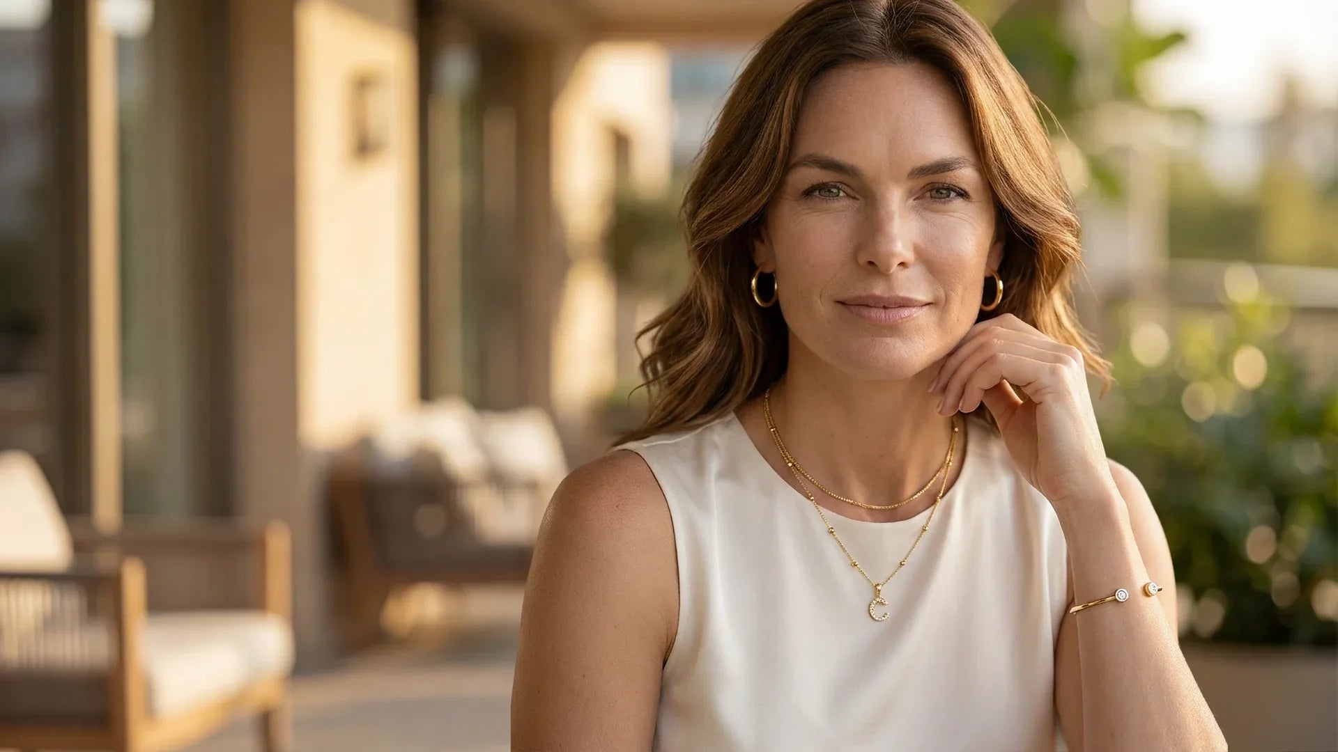 Mujer con joyas Coca Johnson en terraza al atardecer