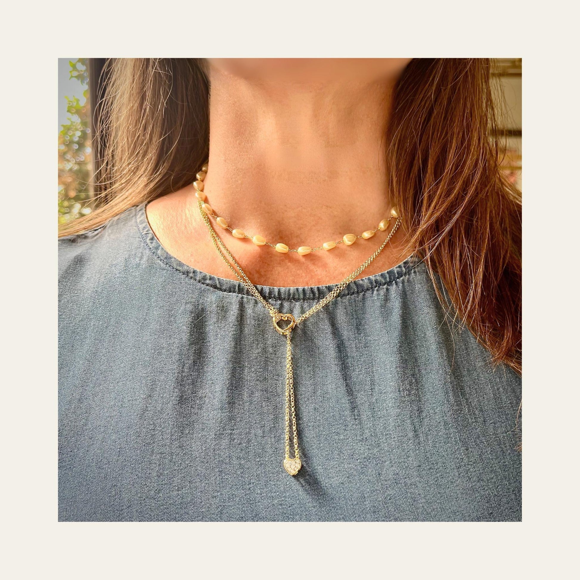 Collar enchapado en oro doble, con doble corazón, circones lo usa una mujer junto a otro collar 