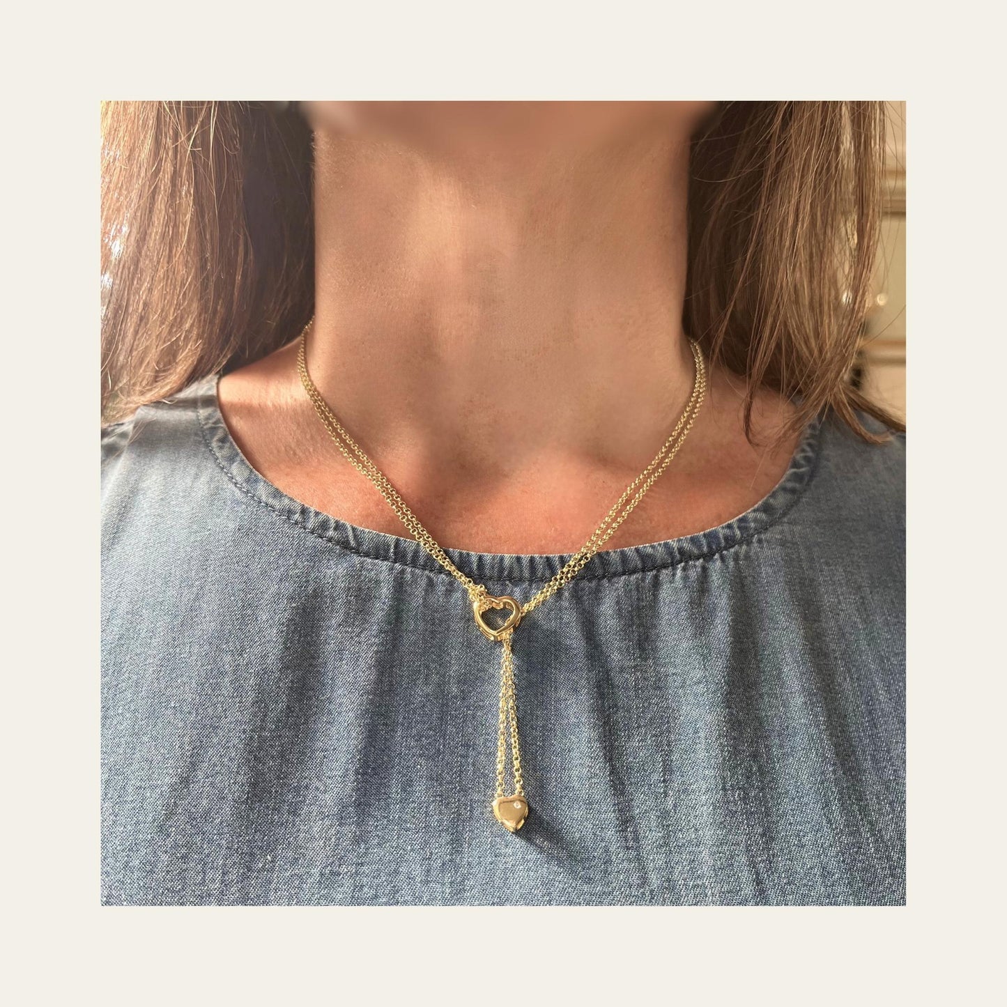 Foto de collar enchapado en oro con doble cadena y doble corazón, lo usa una mujer