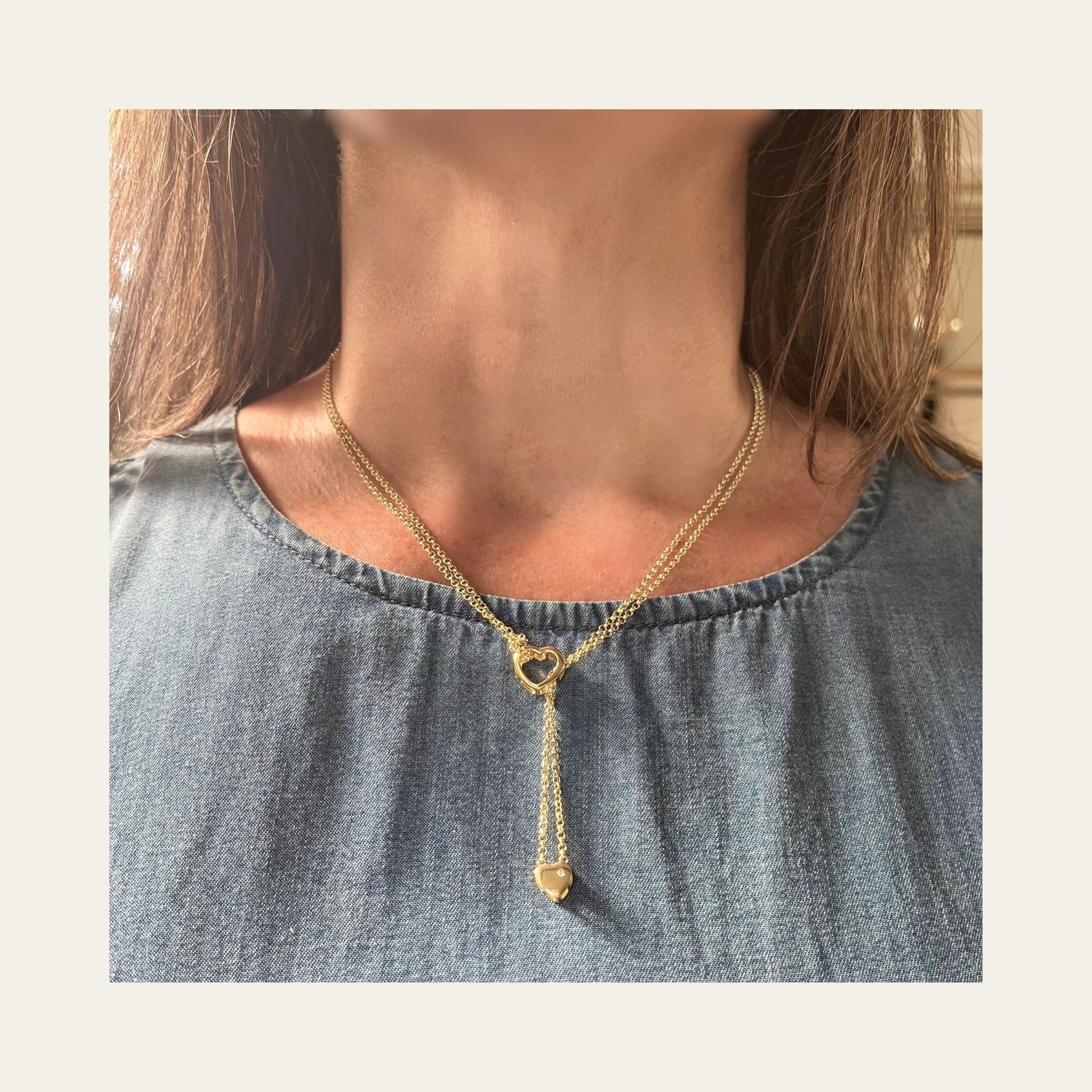 Foto de collar enchapado en oro con doble cadena y doble corazón, lo usa una mujer