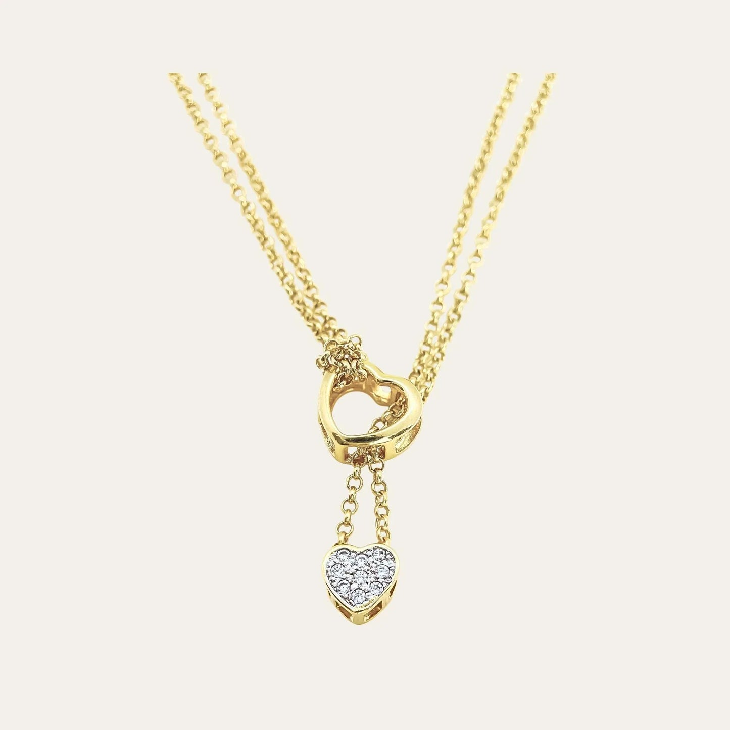 Detalle frontal collar enchapado en oro de doble cadena y doble corazón, con cironces sobre un fondo blanco