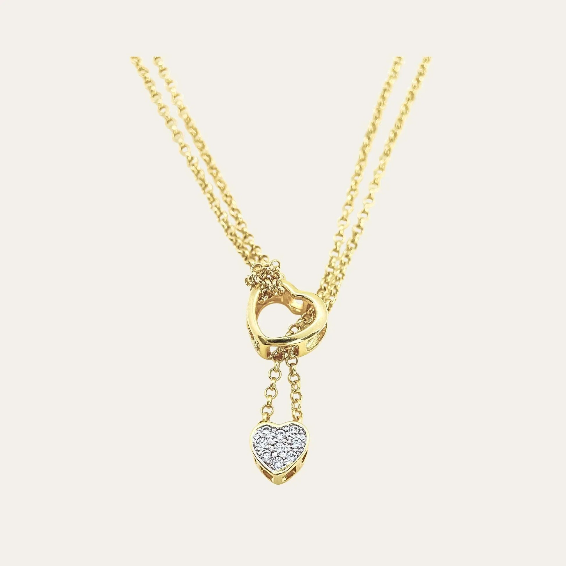 Detalle frontal collar enchapado en oro de doble cadena y doble corazón, con cironces sobre un fondo blanco