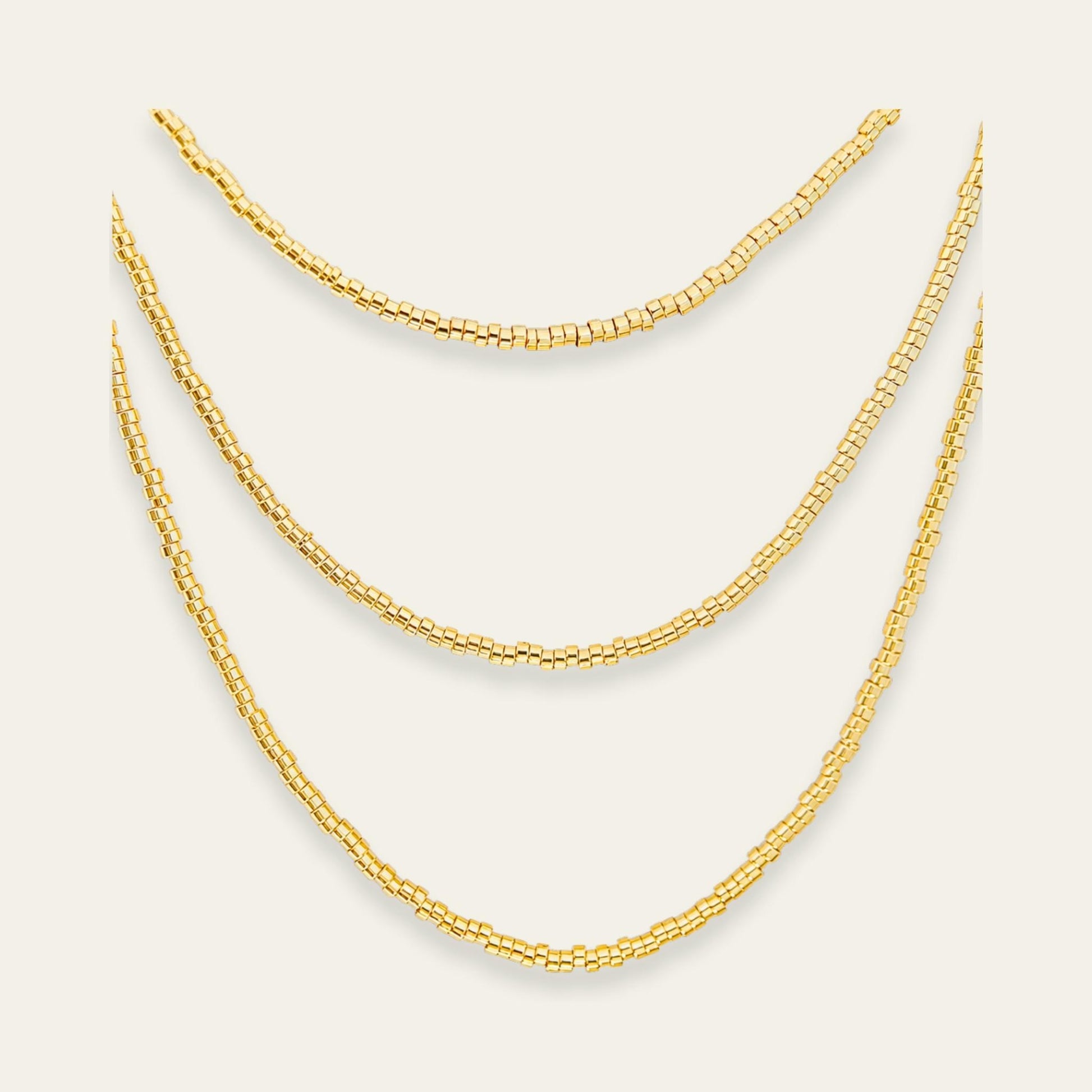 Collar de mostacillas enchapado en oro de 18 kt de 120 cms de largo, sobre fondo blanco - Coca Johnson Joyas - Chile