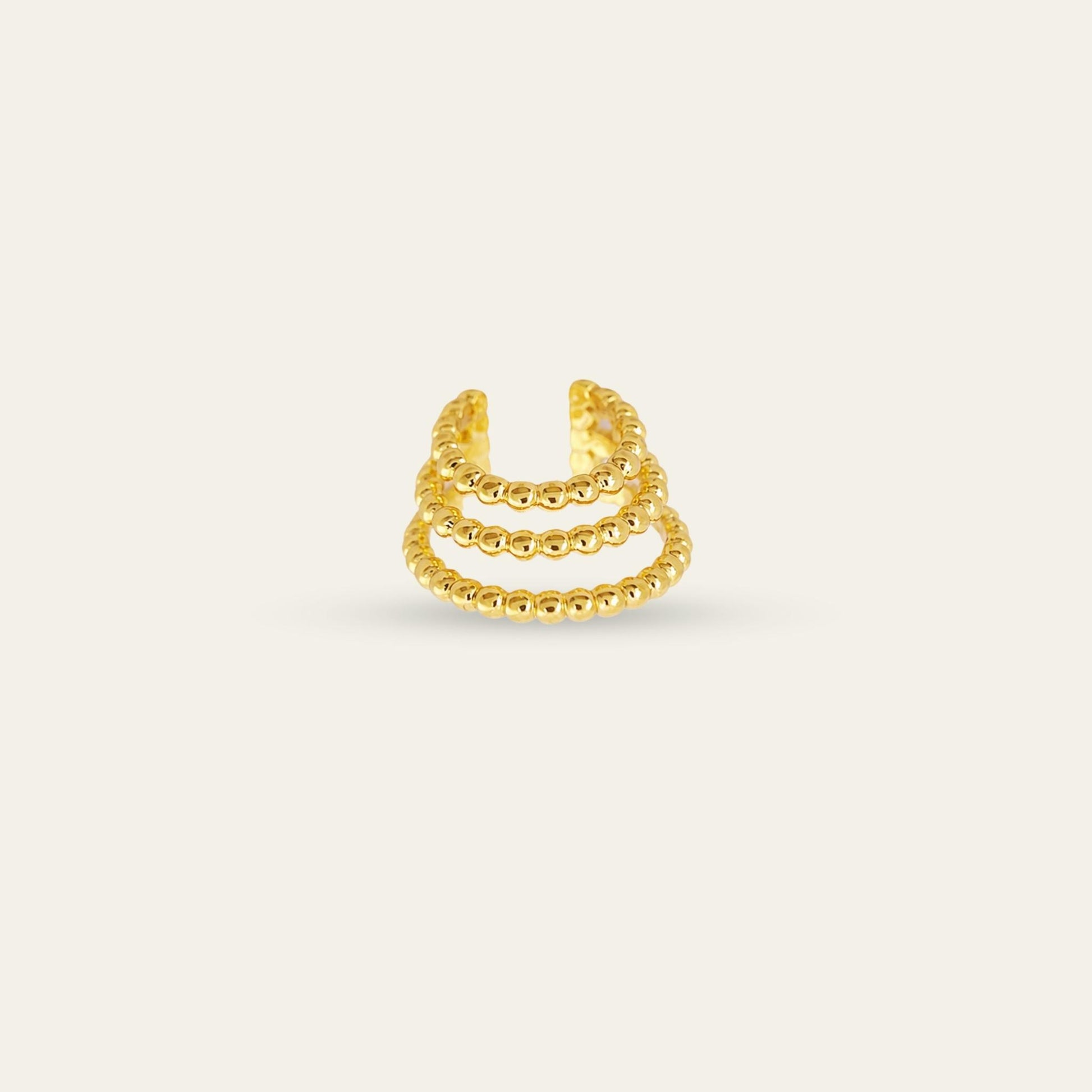 Ear cuff de tres corridas enchapado en oro de 18 kt, sobre fondo blanco - Coca Johnson Joyas - Chile