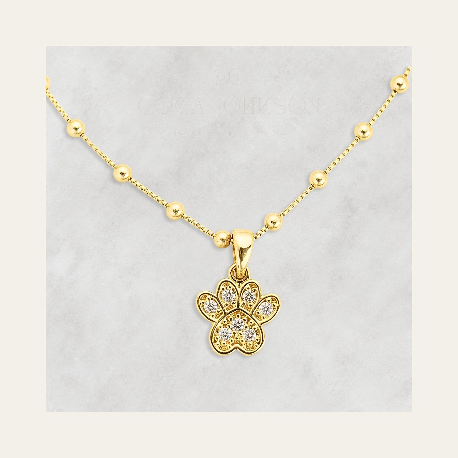 Zoom al charm de patita de perro y circones,  enchapada en oro de 18kt - Coca Johnson Joyas - Chile