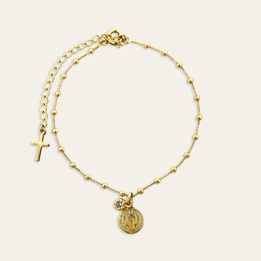 Pulsera enchapada en oro de 18 Kt con colgante de San Benito y circón color agua marina, sobre fondo blanco - Coca Johnson Joyas - Chile