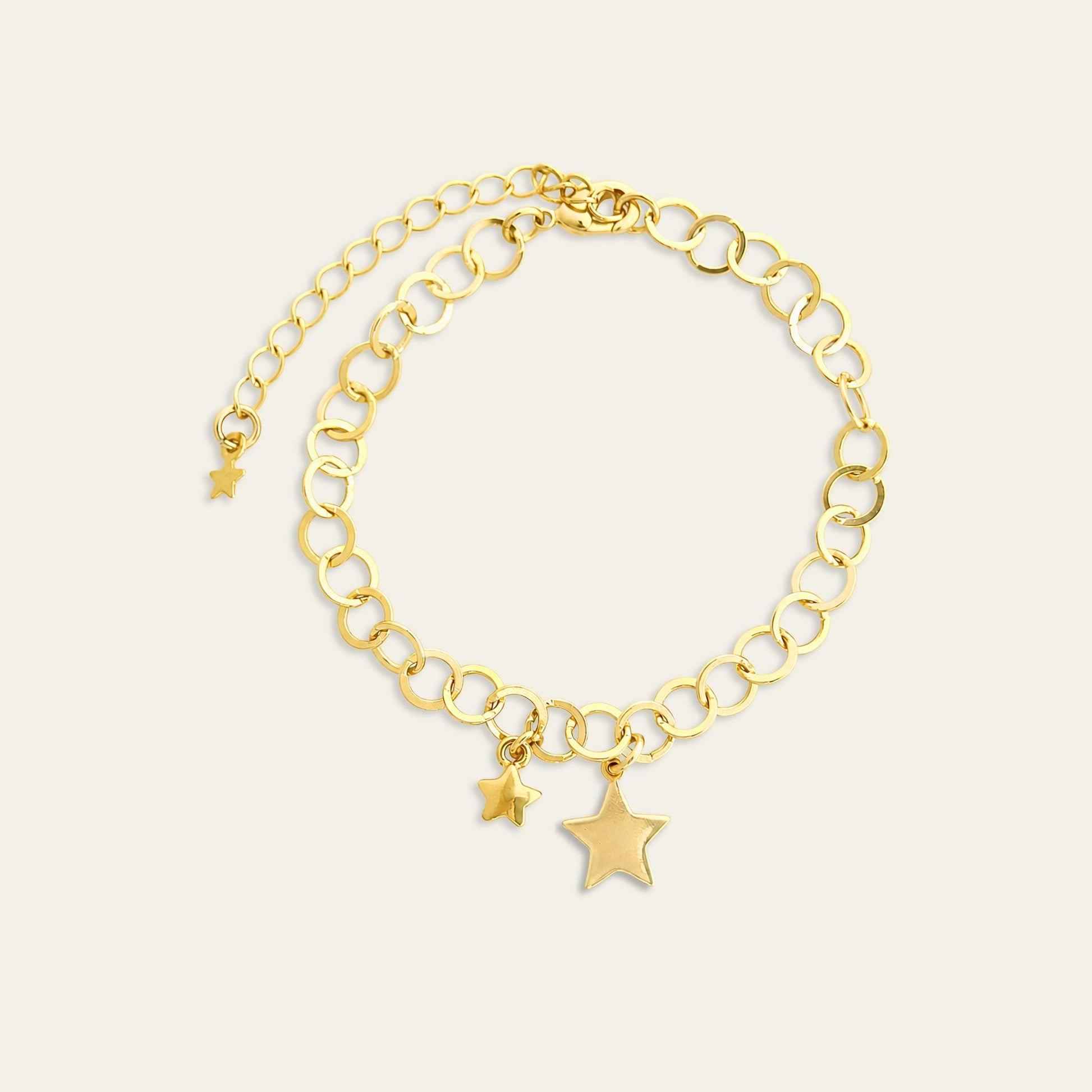 Pulsera con eslabones y dos estrellas colgantes,  enchapada en oro de 18kt, sobre fondo blanco  - Coca Johnson Joyas - Chile
