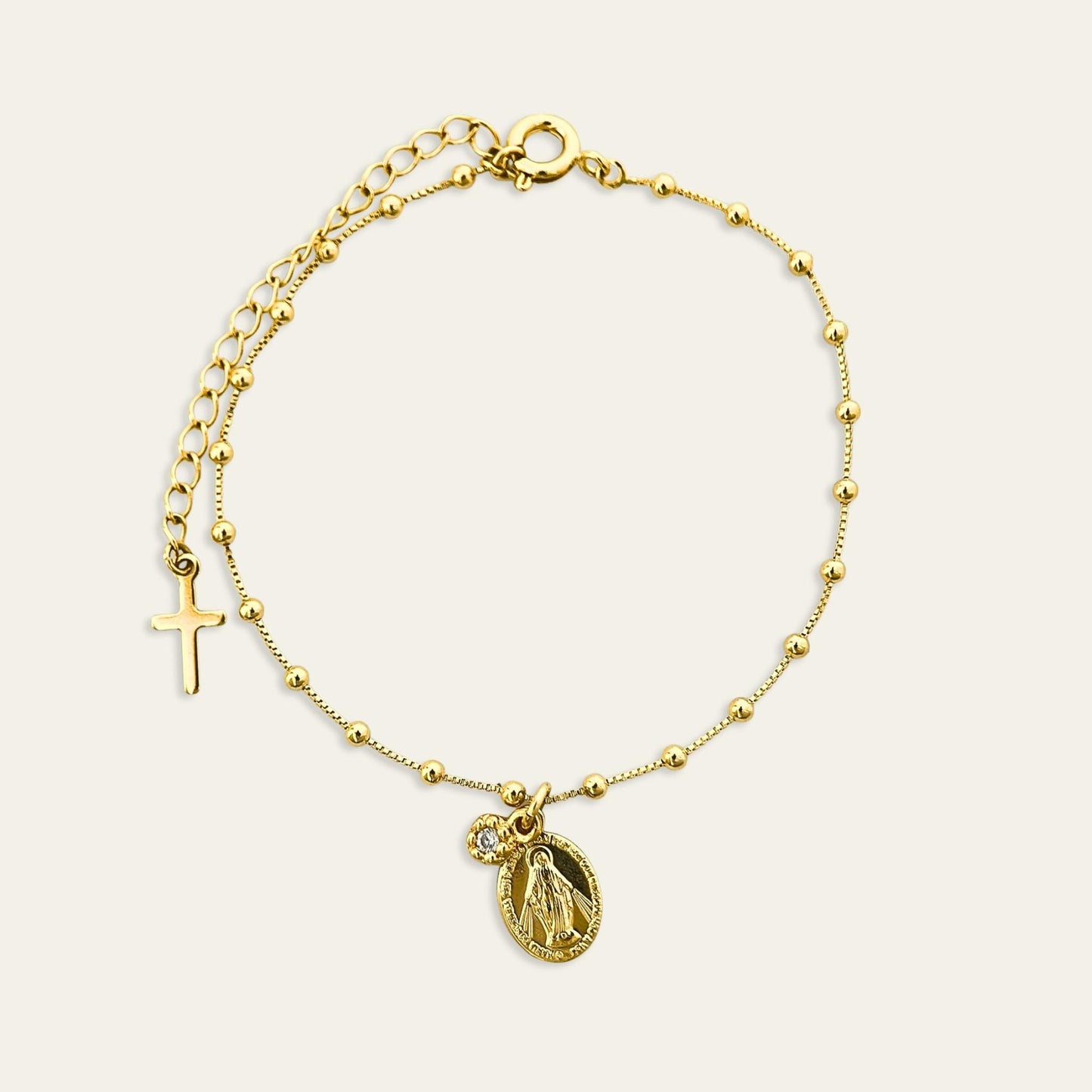 Pulsera enchapada en oro de 18 Kt con colgante de Virgen de los Rayos y circón, sobre fondo blanco - Coca Johnson Joyas - Chile